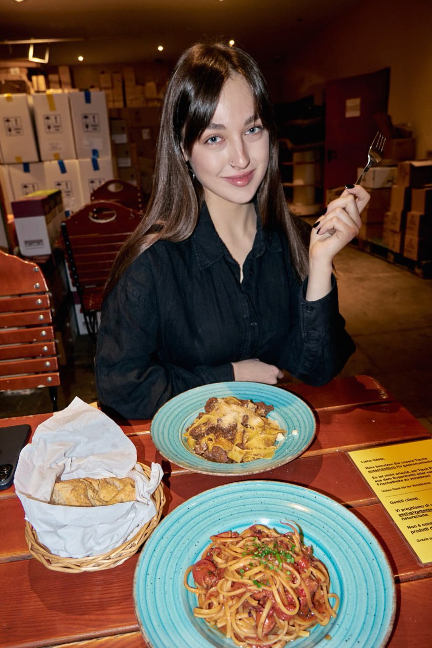 Katya at a table inside Centro Italia with pappardelle al ragù di cervo and linguine with baby octopus