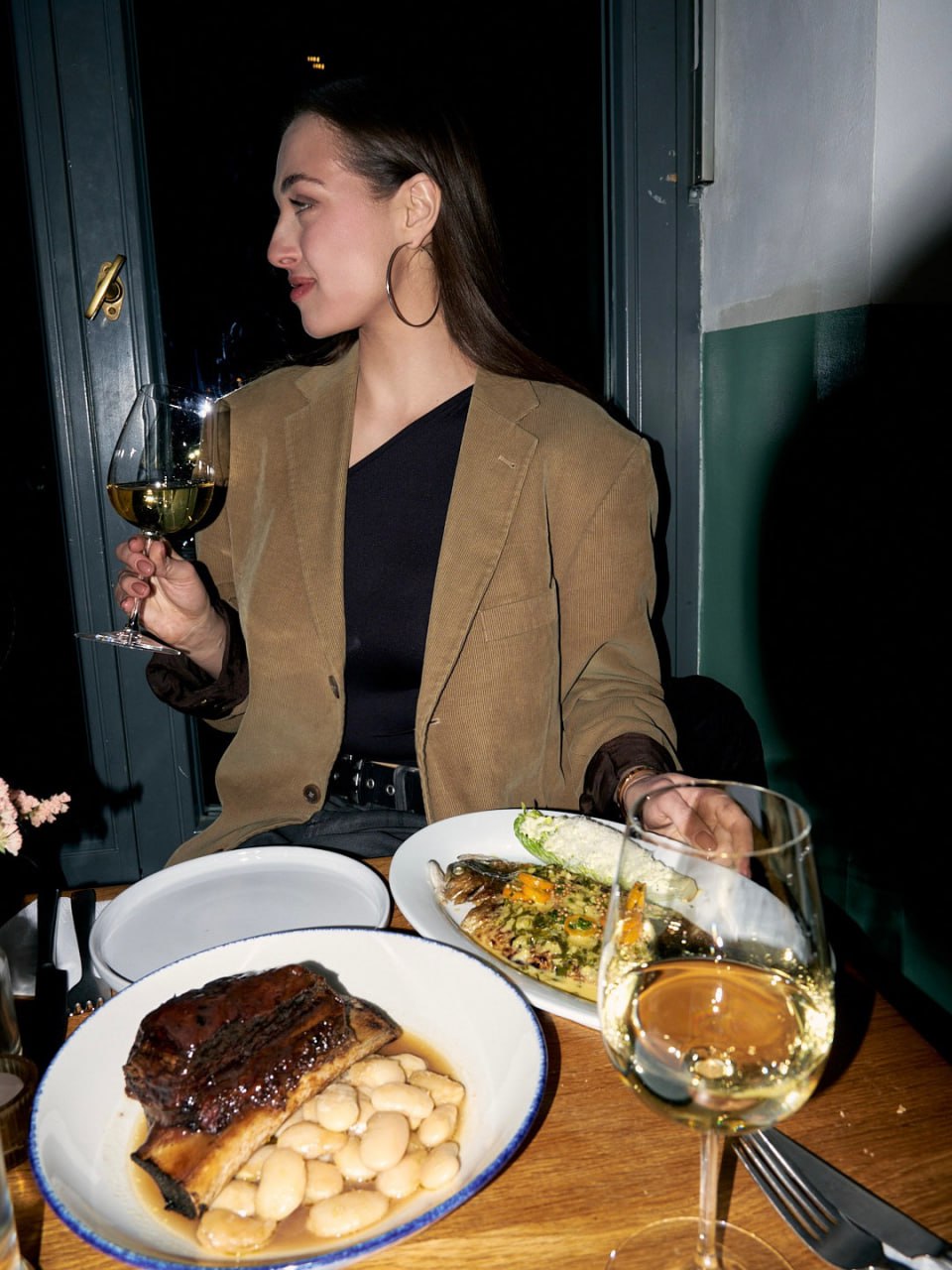 A guest at AVIV 030 with a glass of Riesling