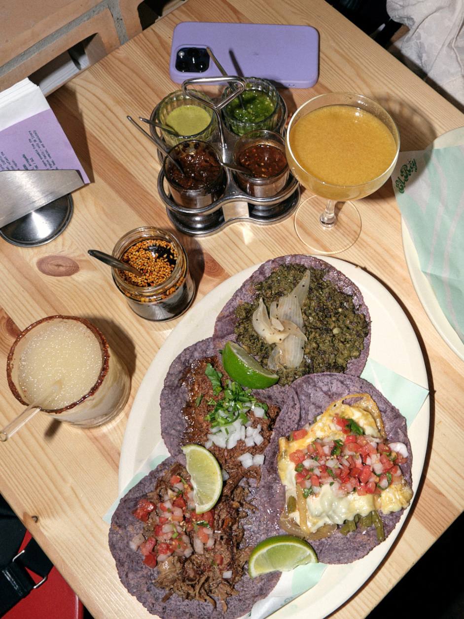 A plate of blue-corn tacos with salsas and a mezcal cocktail at Tacos El Rey